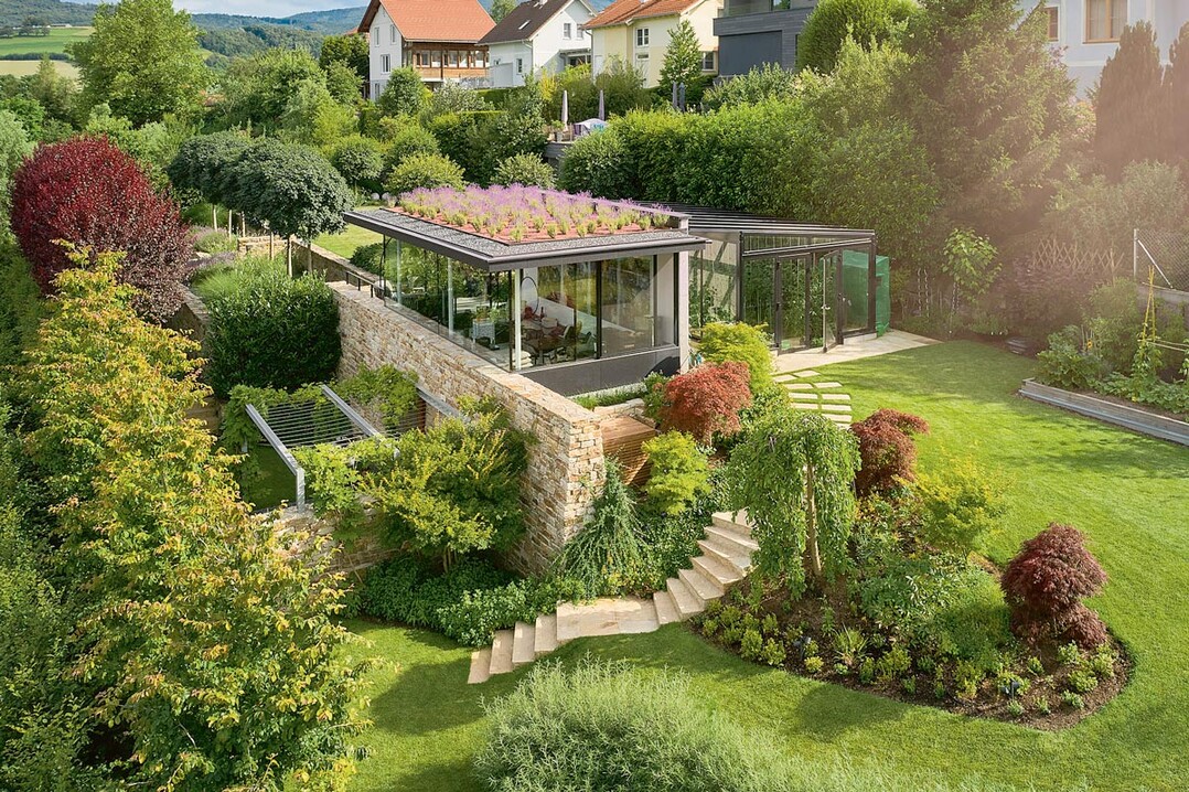 Privatgarten mit ästhetisch undoptisch harmonisch integrierten Flächen für den Anbau von Gemüse, Kräutern und Obst. Der über dem Lagerkeller liegende Pavillon dient als Lounge. Das Dach ist mit Lavendel bepflanzt und bietet vom Wohnzimmer aus gesehen ein leuchtendes Blütenmeer, das an die Provence erinnert.