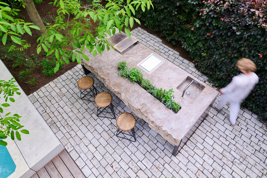 Als skulpturaler Mittelpunkt im Freien verbindet MKA01 von Hauser Naturstein rauen Stein mit pr�zisem Stahl zu einem funktionalen Ort der Begegnung und des kulinarischen Genusses.