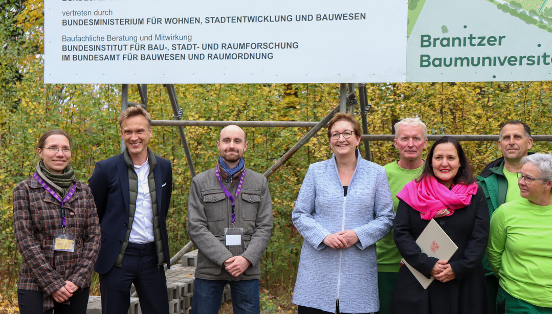 Karola Weber, Projektmitarbeiterin Branitzer Baumuniversitt (SFPM), Dr. Stefan Krner (SFPM), Christoph Haase (SFPM), Bundesministerin Klara Geywitz, Ministerin Dr. Manja Schle und GrtnerInnen der Stiftung Frst-Pckler-Museum vor dem Bauschild der Neuen Branitzer Baumuniversitt (v.l.n.r.).