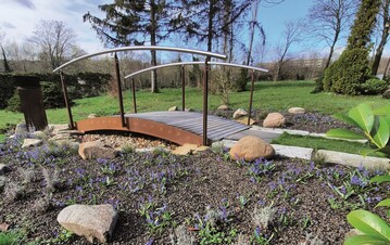 Die gebogene Brcke aus Metall als Gestaltungselement und zur Strukturierung im
Garten