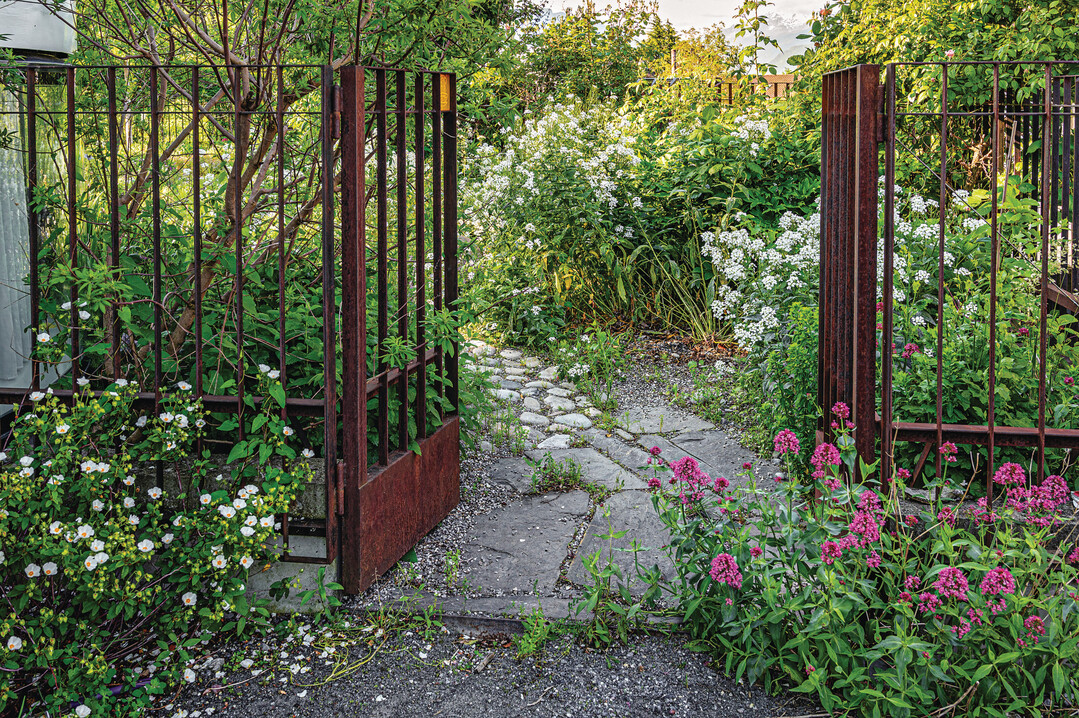 Privater Gartenteil und Werkhof sind gestalterisch durch das Material und die Bepflanzung verbunden.