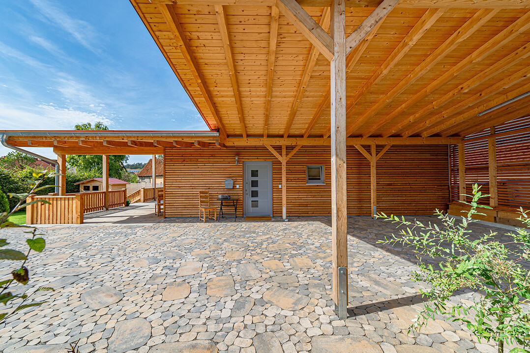 Pflasterflchen mit Arena sind in jedem Fall ein Eyecatcher. Hier harmoniert der naturnahe Look mit der Holzbauweise des Hauses.